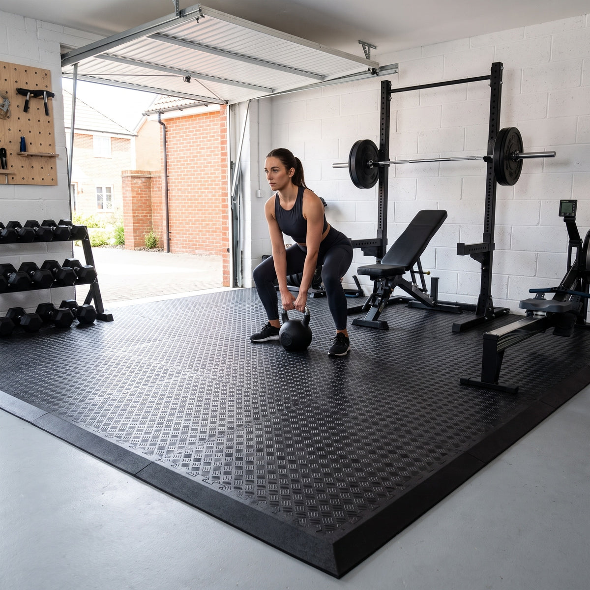 Kettlebell deadlift in a garage gym floored with DuraSof 18mm checker-plate rubber gym tiles and black ramp edges