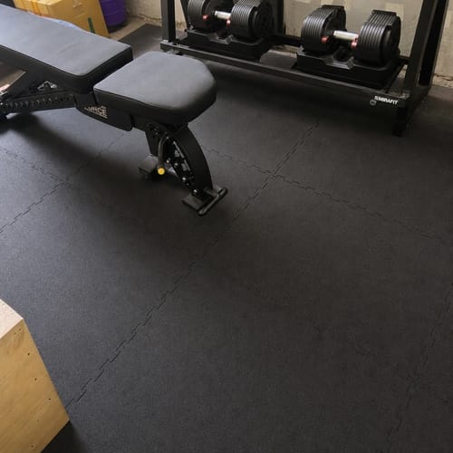 Customer photo: 16mm heavy duty rubber gym tiles under a weight bench and dumbbell rack in a home gym