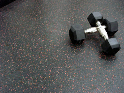Heavy duty rubber gym flooring roll installed in large commercial gym — seamless coverage